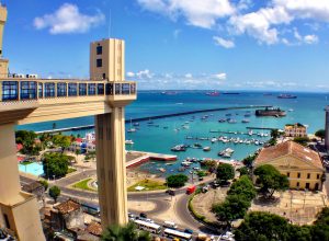Vista do Pelourinho e do Elevador Lacerda em Salvador (BA), com casarios históricos e a Baía de Todos-osSantos ao fundo.