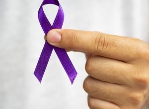 close-up-person-holding-up-purple-ribbon.jpg